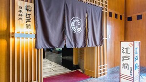 A traditional Japanese entrance with a wooden structure, a red carpet, and a sign with Japanese characters. - Ruishi Hotel Dalian (Dalian)