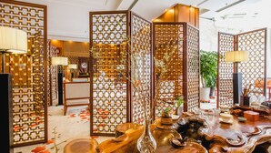 A traditional interior with wooden partitions, a wooden table with decorative items, and a vase. - Ruishi Hotel Dalian (Dalian)
