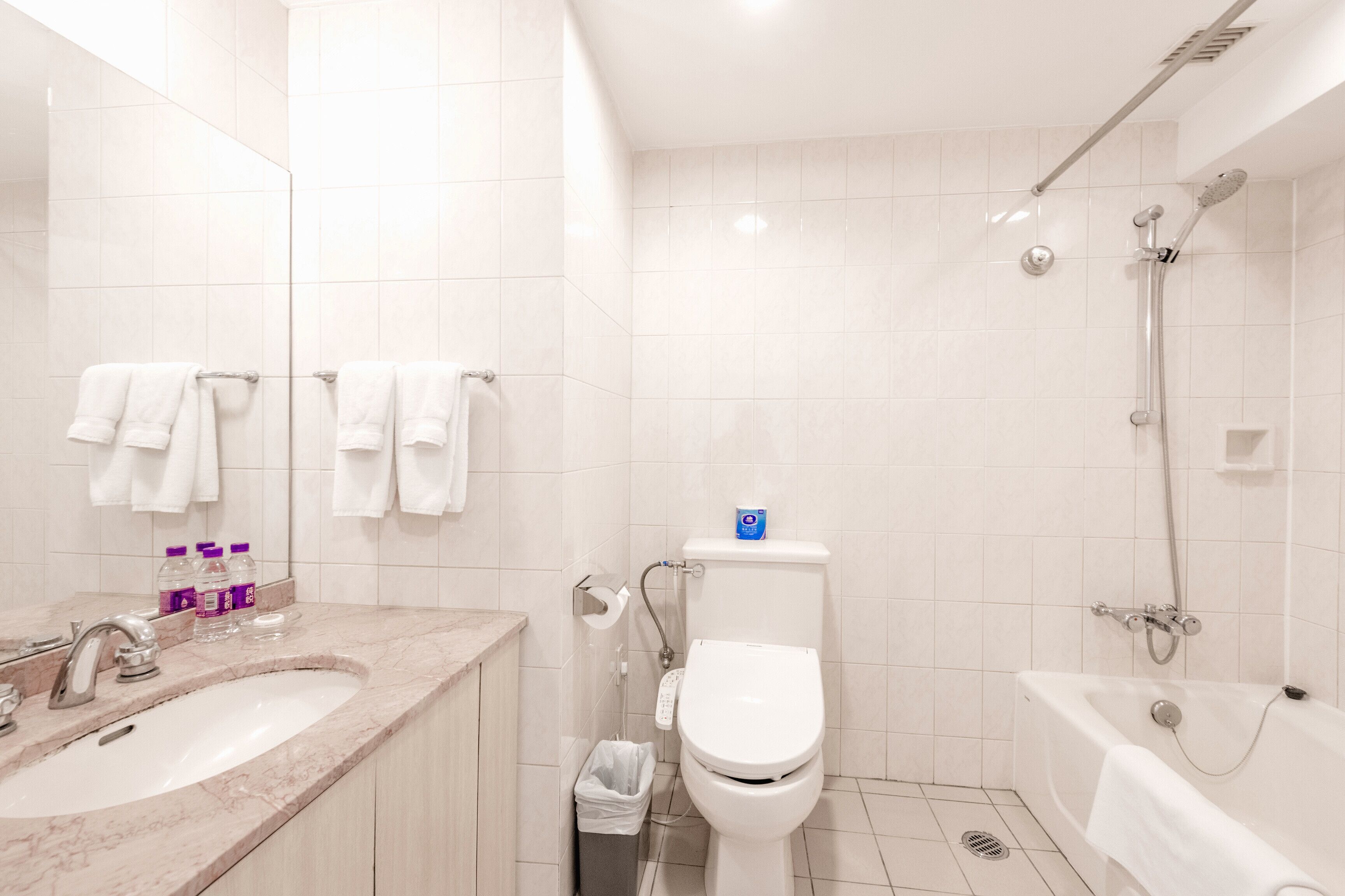 A modern bathroom with a sink, toilet, and bathtub.