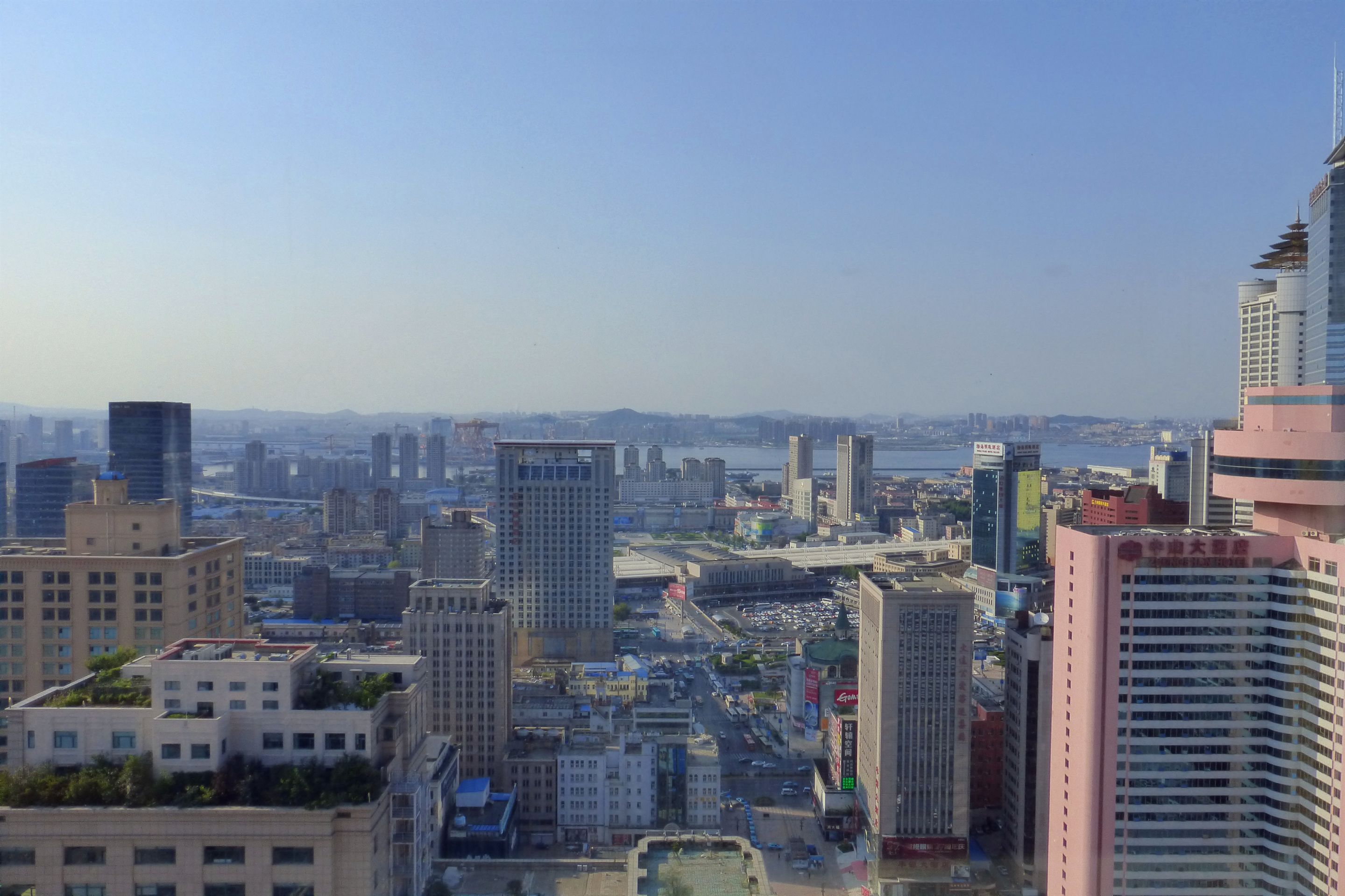 A cityscape with high-rise buildings, a river, and a bridge.
