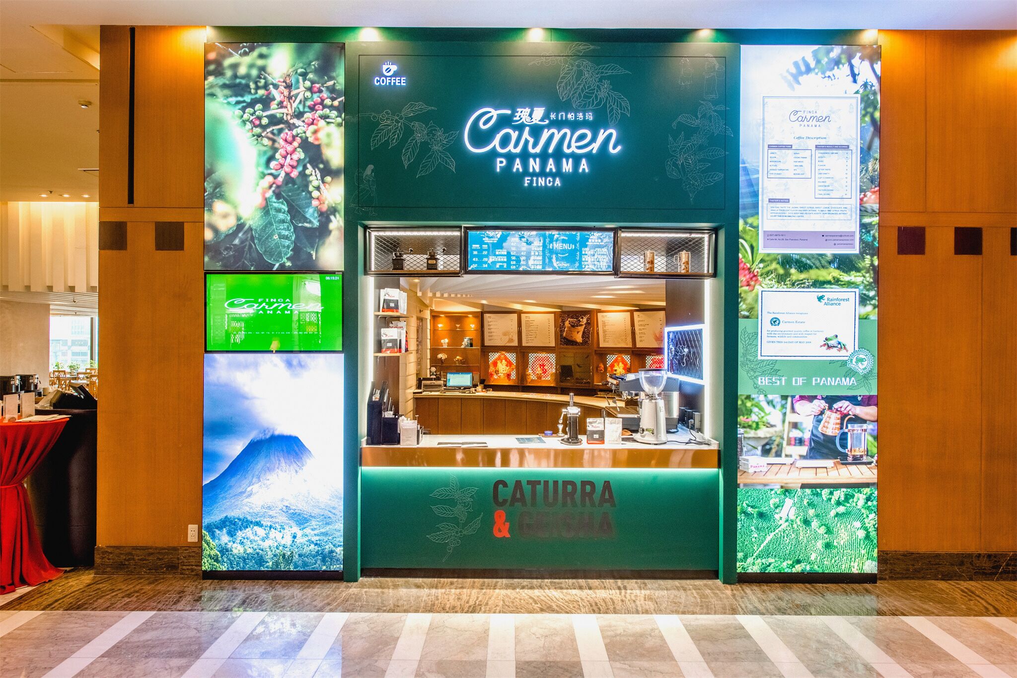 A hotel lobby with a green reception desk labeled "Carmen Panama Finca" and "Caturra & Geisha" coffee.