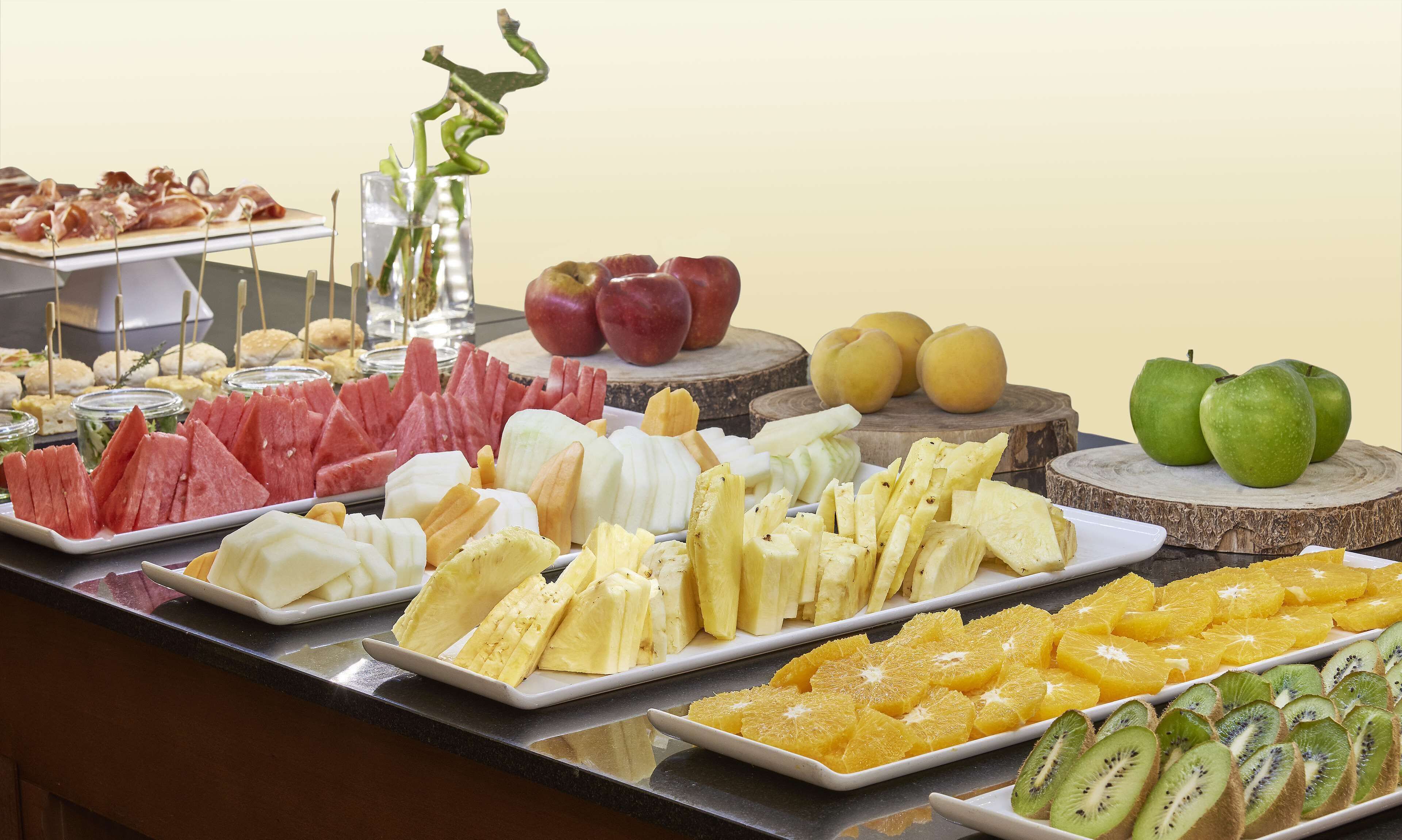 A buffet with various fruits and cheeses.