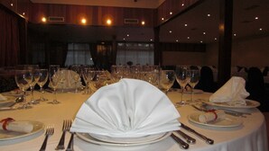 A banquet table set with white tablecloths, plates, glasses, and cutlery. - Hotel El Hidalgo (Valdepenas)
