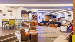 A modern interior with a seating area, a staircase, and a display of furniture. - Exe Coruña (A Coruña)