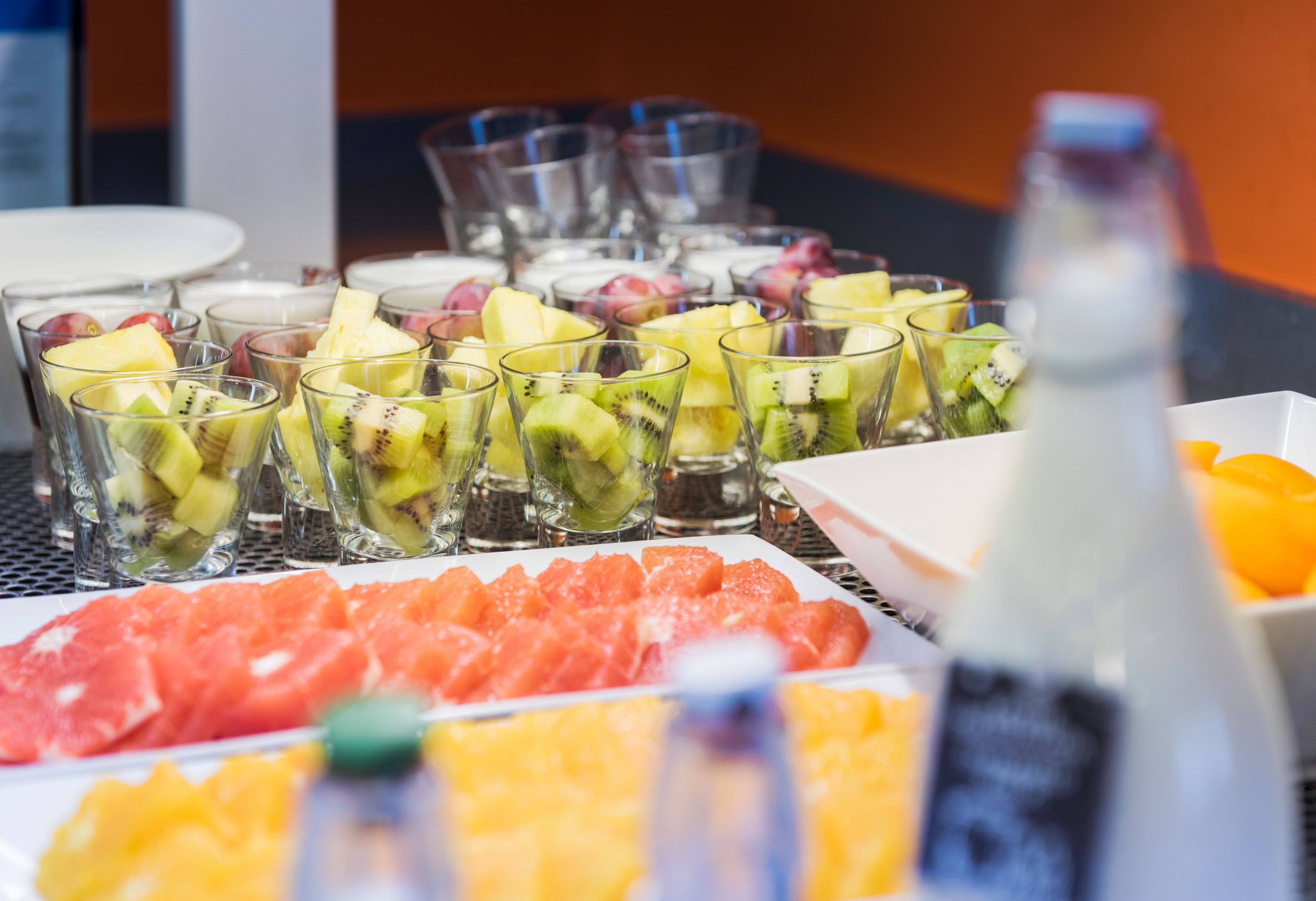 Un bufé con varias frutas y una botella de agua.