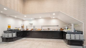 Una barra de desayuno moderna con una pared de diseño chevron, un mueble negro y gris, y un suelo de baldosas.