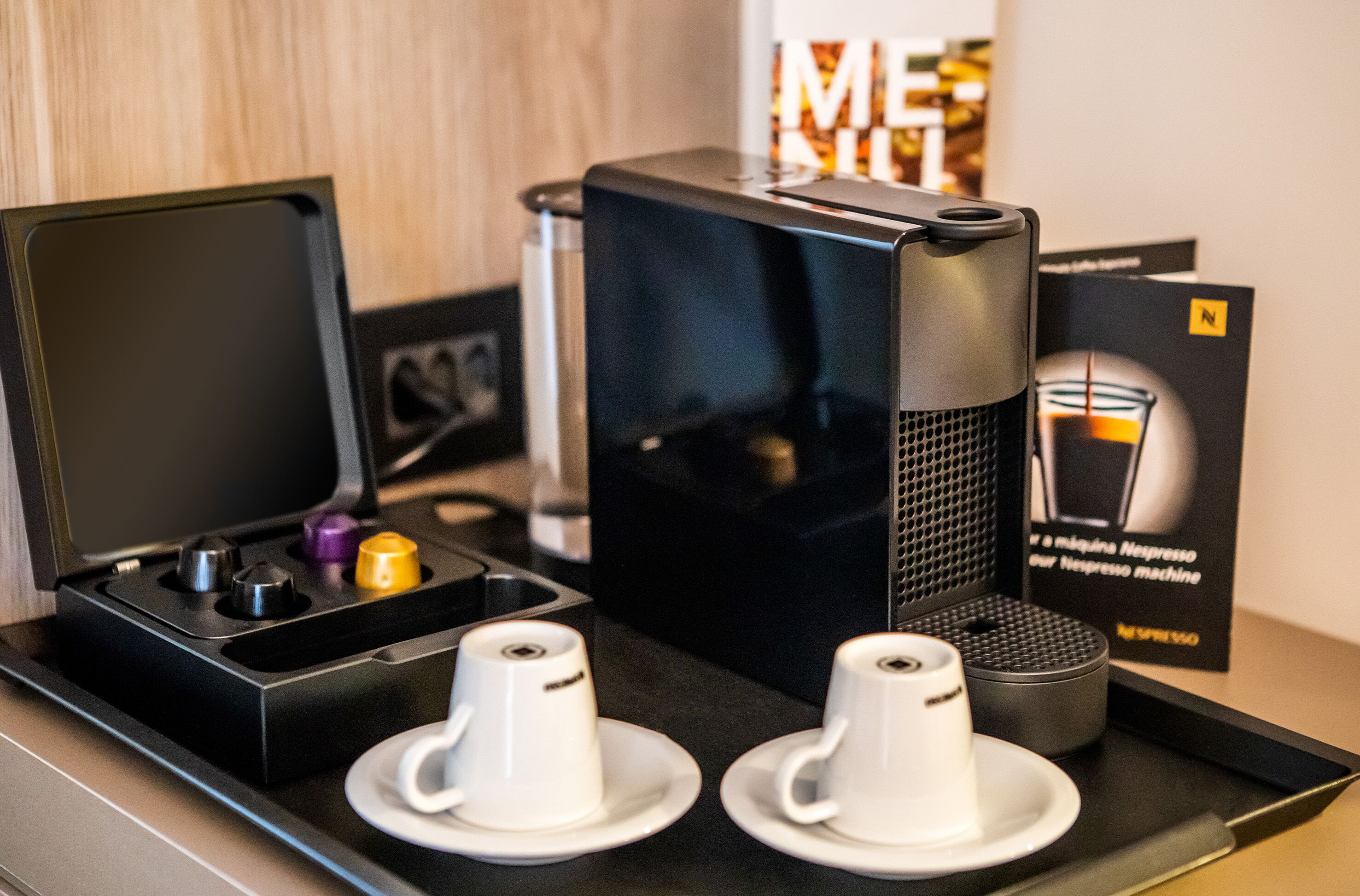 A Nespresso coffee machine with two cups on a tray.