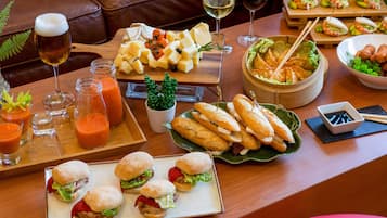 A dining table with various food items, including sandwiches, cheese, and a bowl of soup.