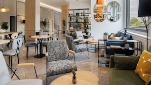 A modern interior with seating areas, a coffee bar, and a view through large windows.