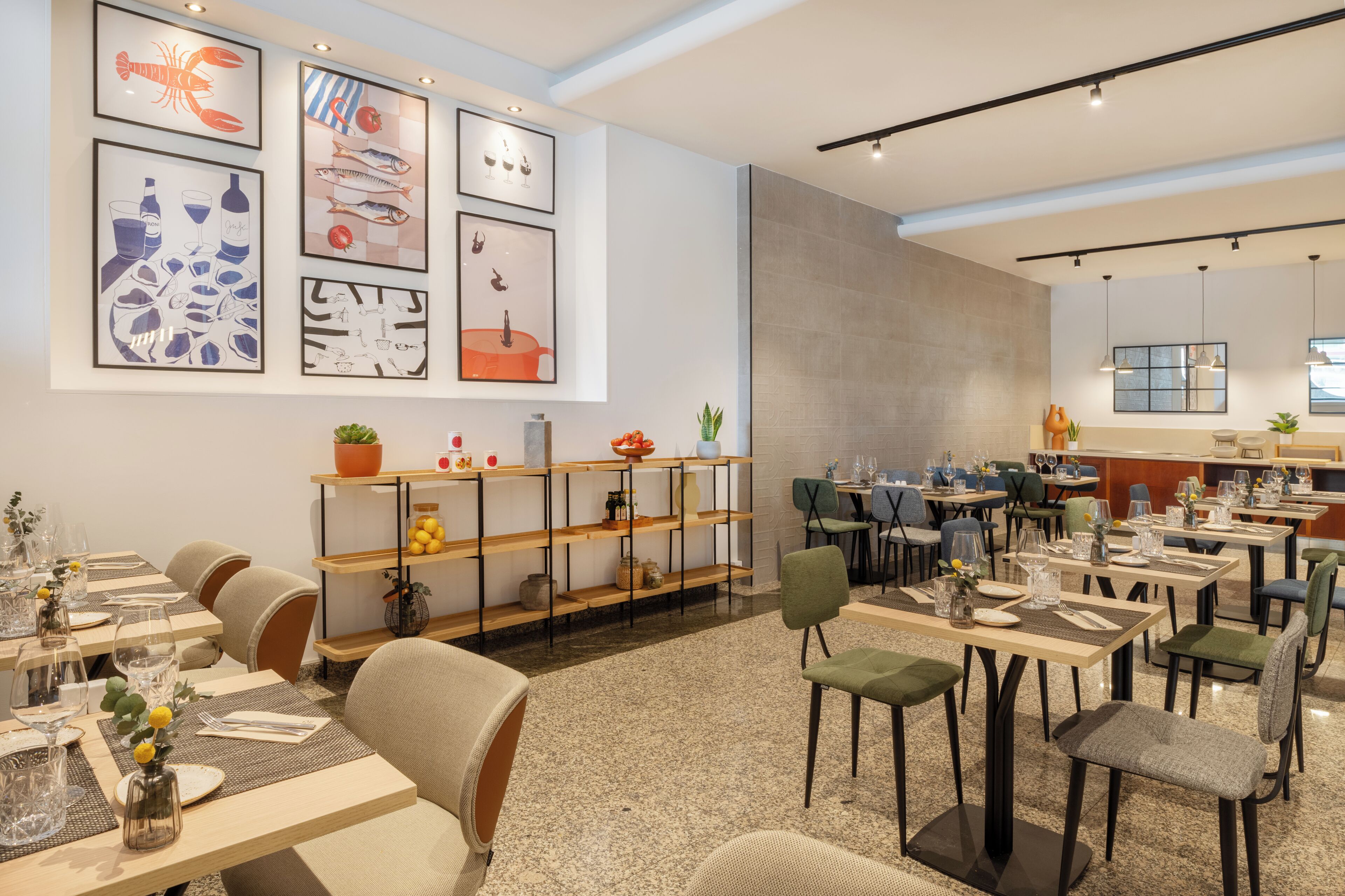 A modern dining area with multiple tables and chairs, framed artwork on the walls, and a variety of plants and decorative items.