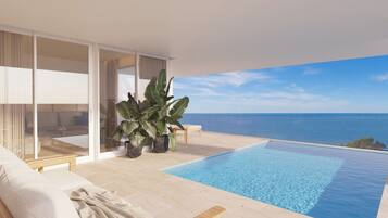 A modern infinity pool with a clear view of the ocean, a comfortable seating area with a sofa and a bench, and large potted plants.