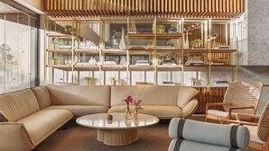 Una sala de estar moderna con un sofá seccional, una mesa de centro redonda y un sillón de mimbre.