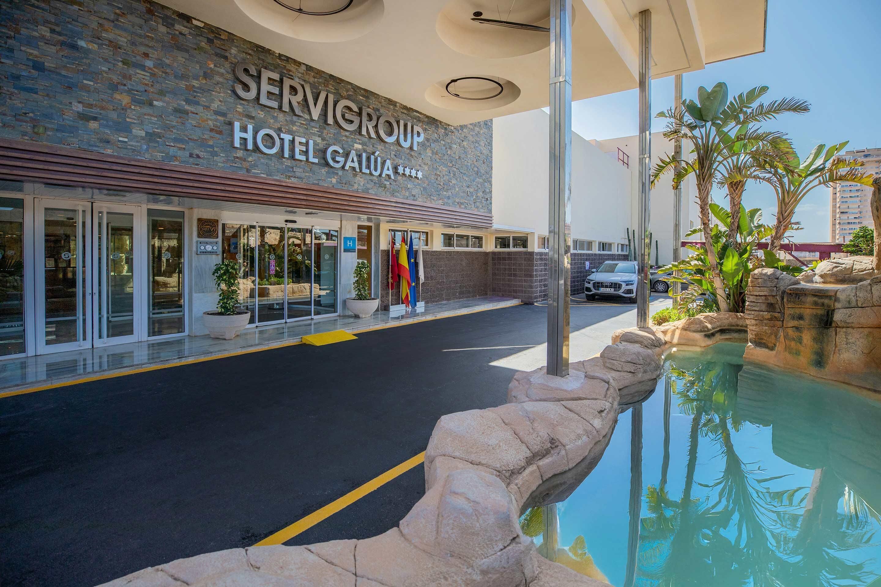 Exterior del Servigroup Hotel Galua, amb zona de piscina i un camí de pedra que condueix a l'entrada.