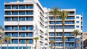 A multi-story hotel with balconies, palm trees, and a clear blue sky. - INNSiDE by Meliá Costablanca - Adults recommended (Benidorm)