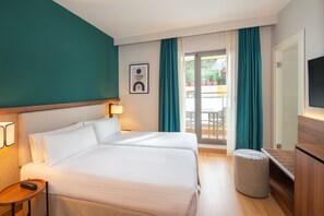 Une chambre d’hôtel avec un lit, une table de chevet, une lampe et un téléviseur.