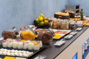 Un buffet proposant une variété d’aliments, notamment des fruits, des céréales et des produits laitiers.