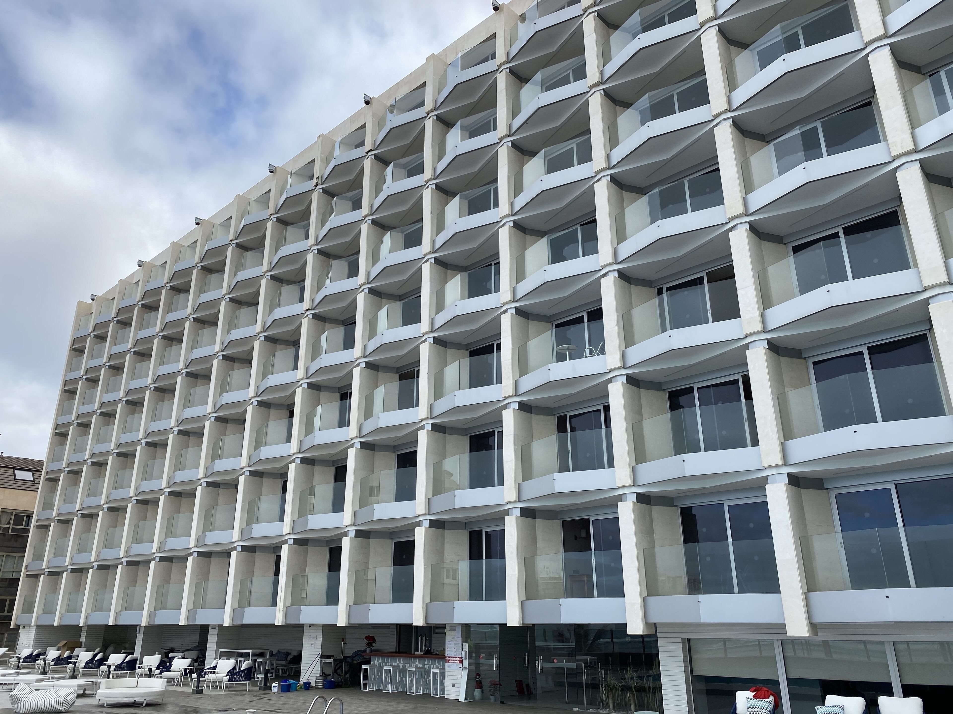 A modern building with a grid of balconies and large windows.
