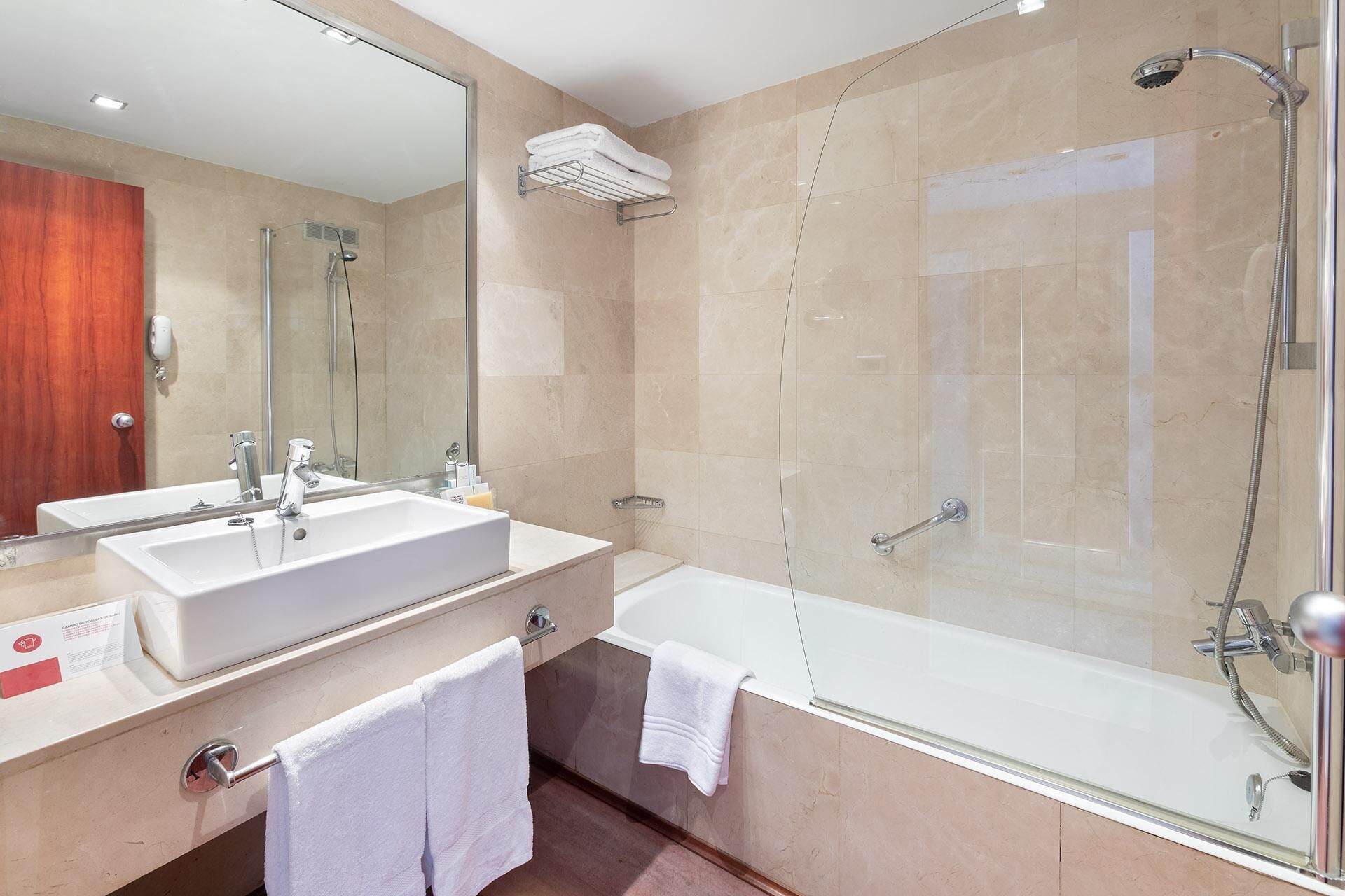 Une salle de bain moderne avec deux lavabos, un grand miroir, une douche et une baignoire.