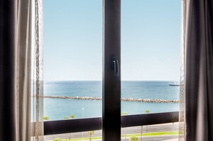 Blick aus einem Fenster auf das Meer und ein Schiff in der Ferne.