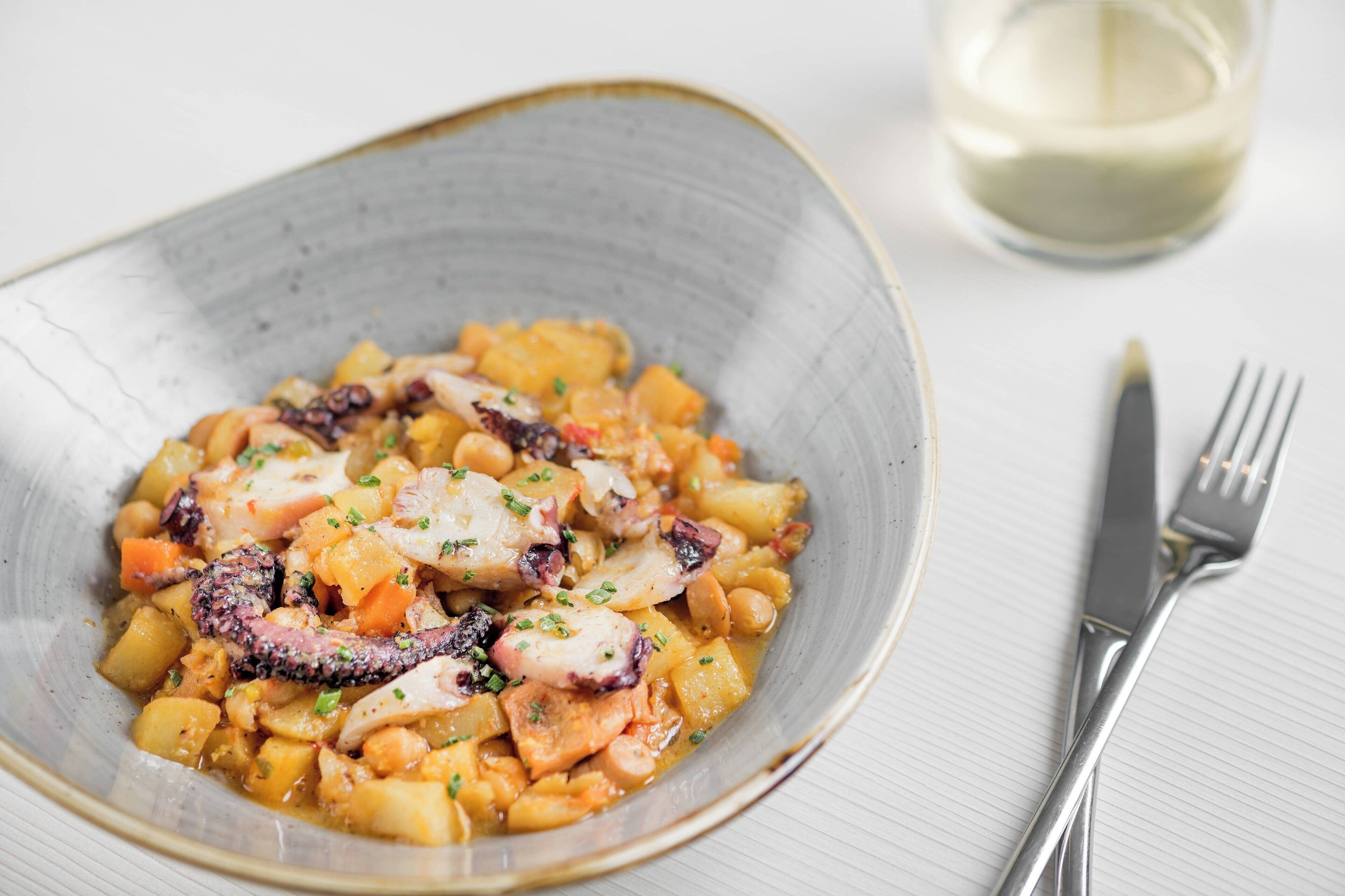 Eine Schüssel Essen mit Gabel und Messer daneben.