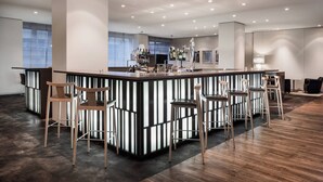 A modern bar area with a central island, bar stools, and a wooden floor. - AC Hotel Iberia Las Palmas (Las Palmas de Gran Canaria)