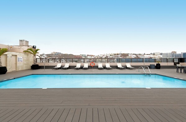 Piscine extérieure, parasols de plage, chaises longues