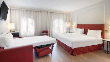 A hotel room with two beds, a TV, a desk, and a chair.