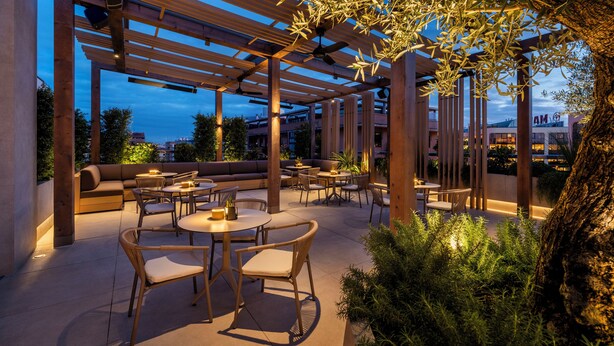 An outdoor patio area with wooden pergolas, seating, and tables.