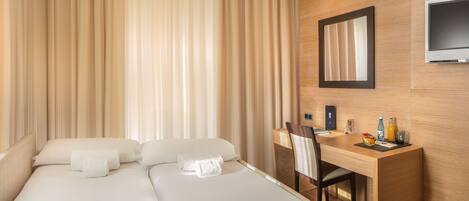 Una habitación de hotel con una cama, un escritorio y un televisor.