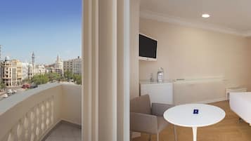 Relax in a spacious room with a balcony offering panoramic city views, a comfortable bed, and a convenient workspace.