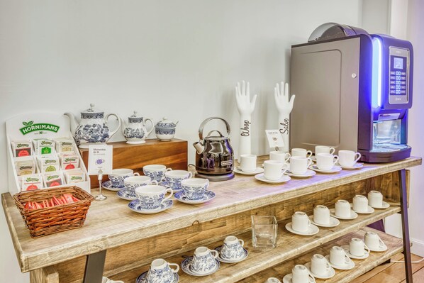 A display of tea sets, a coffee machine, and a basket of tea bags. - Sercotel Arenal Bilbao (Bilbao)
