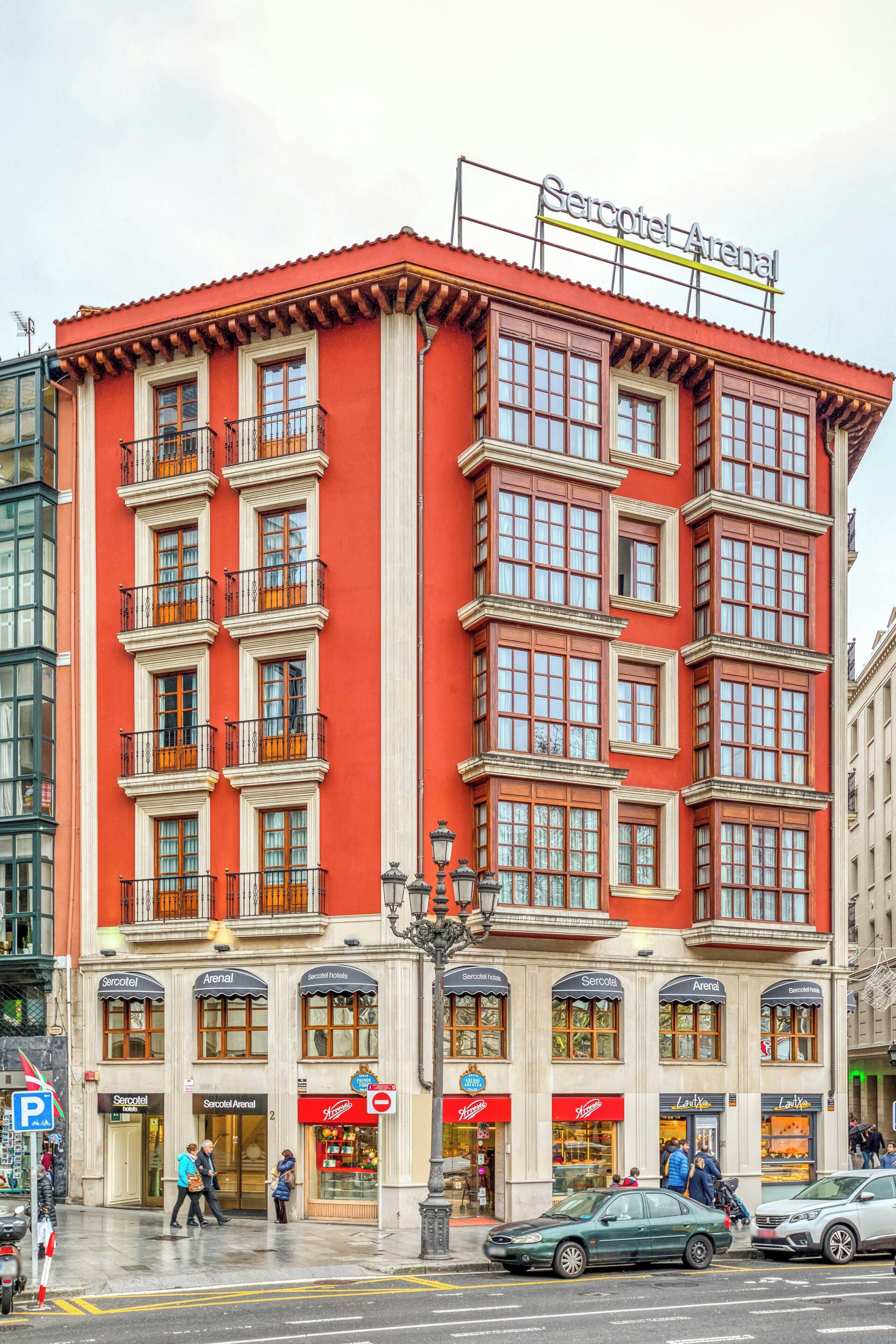 Un edificio rojo con varias ventanas y balcones, con la etiqueta 'Seicotel Arenal'.