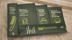 Un conjunto de cuatro cajas verdes con texto e iconos, cada una identificada con un artículo diferente: peine, kit de tocador femenino, pañuelos de papel y gorro de ducha.