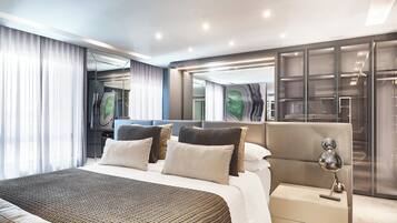 A modern bedroom with a large bed, a bedside table, a mirror, and a wardrobe.