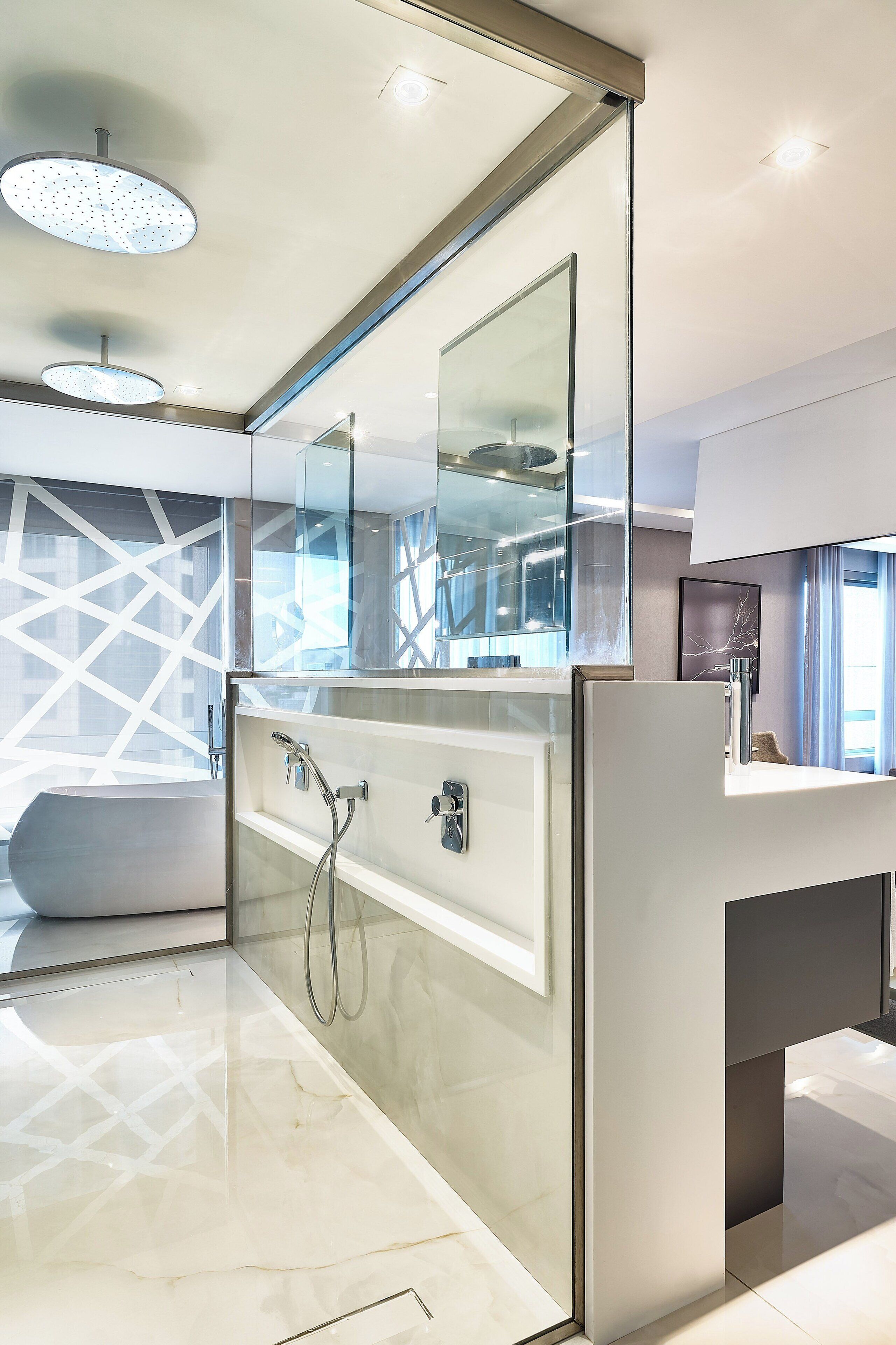 A modern bathroom with a large mirror, a bathtub, and a shower area.