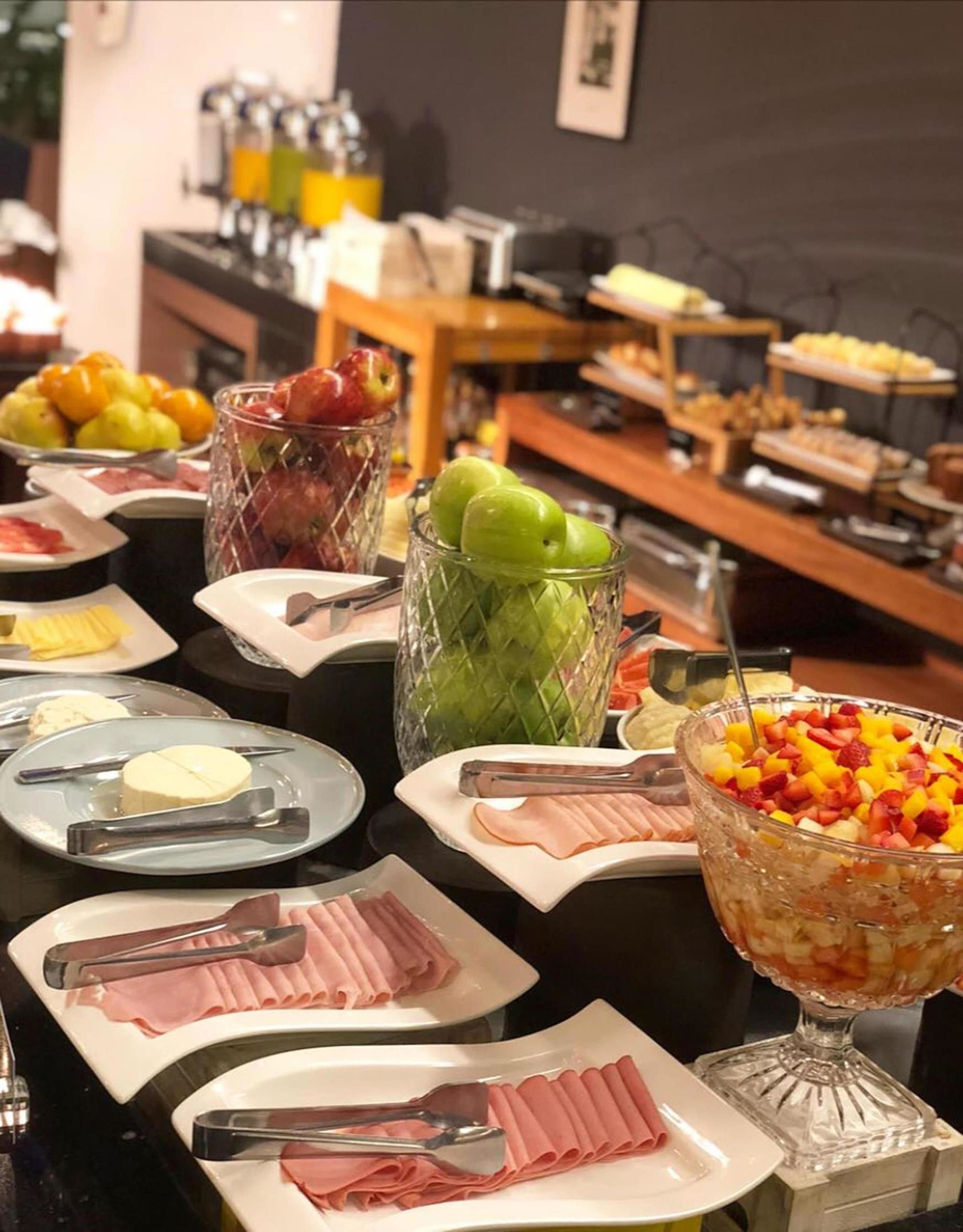 Un buffet proposant une variété de plats, notamment des fruits, des fromages et des viandes.