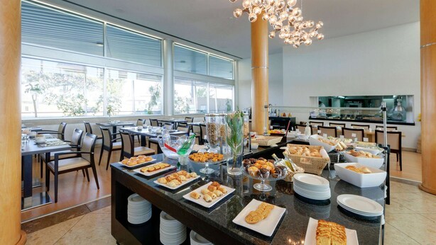 A buffet setup with various food items and a modern chandelier. - TRYP by Wyndham Porto Expo Hotel (Matosinhos)