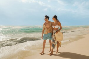 En la playa, arena blanca, sombrillas, toallas de playa