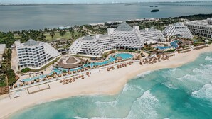 A resort with multiple hotel buildings, a beach, and a swimming pool. - Paradisus Cancún – All Inclusive (Cancun)