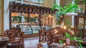 An indoor dining area with wooden furniture, a glass display case, and hanging pendant lights. - Paradisus Cancún – All Inclusive (Cancun)