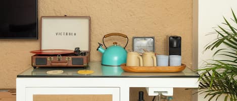 A kitchenette with a vintage radio, a kettle, and a coffee maker on the counter.