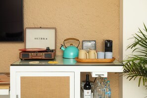 A kitchenette with a vintage radio, a kettle, and a coffee maker on the counter.