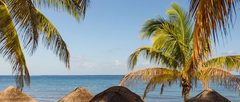 Plage, sable blanc, chaises longues, parasols