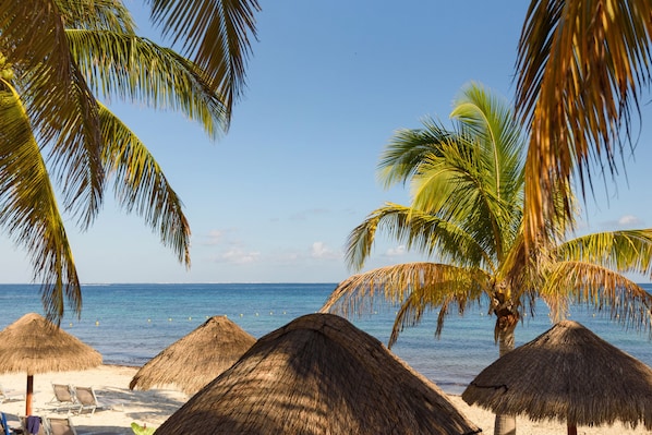 Plage, sable blanc, chaises longues, parasols