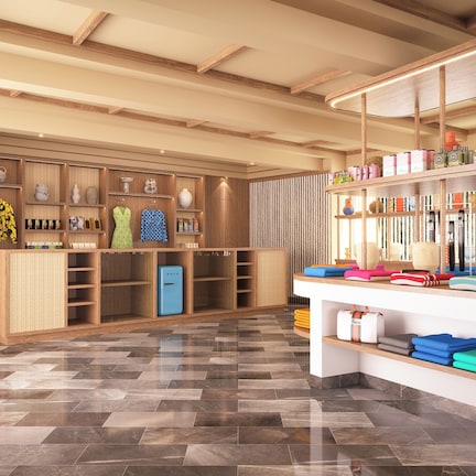 A modern hotel lobby with wooden shelving, a central reception desk, and a patterned floor.
