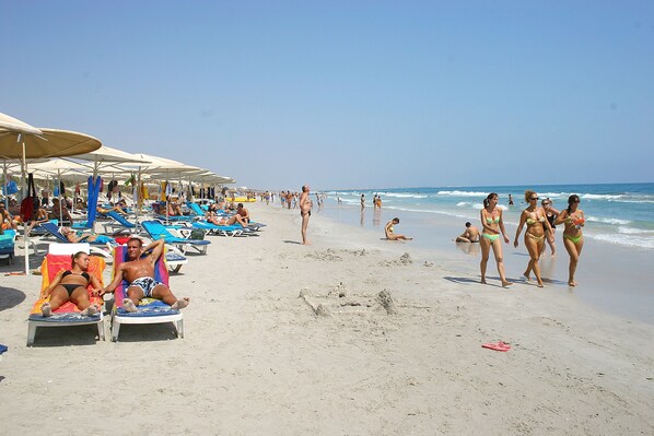 Praia particular, espreguiçadeiras, guarda-sóis, toalhas de praia 