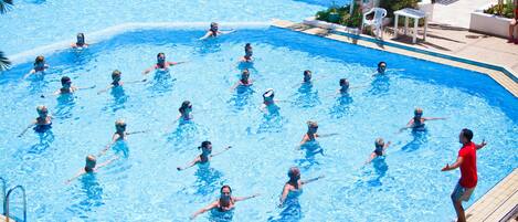 A swimming pool with multiple lanes and people swimming.