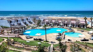 A resort with a large central pool, multiple sun loungers, and a view of the ocean. - Casablanca Le Lido Thalasso & Spa (Casablanca)