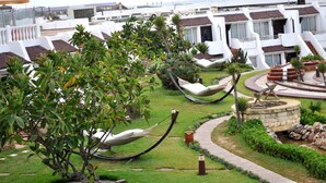 A resort with multiple white villas, a grassy garden with hammocks, and a stone fire pit. - Casablanca Le Lido Thalasso & Spa (Casablanca)