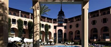 Una piscina al aire libre, sombrillas, tumbonas